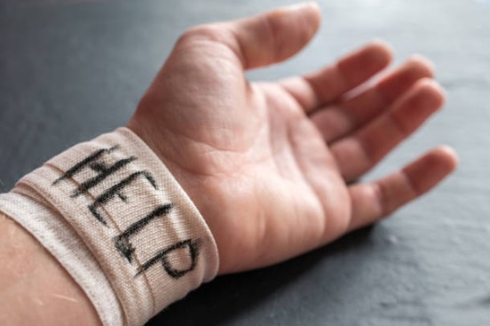 zdjęcie ręki dziecka. Nadgarstek przewiązany bandażem z napisem HELP