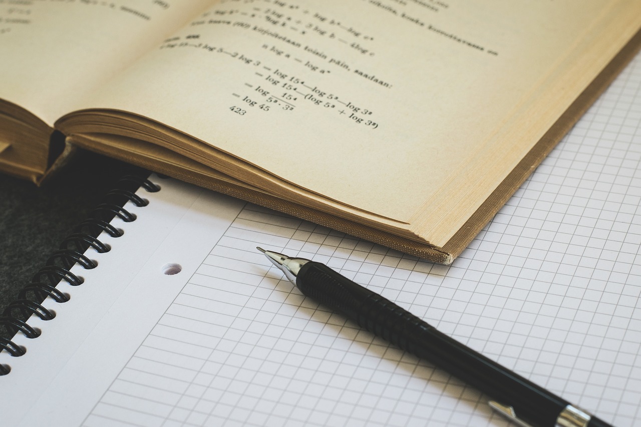 otworzonego zbioru z zadaniami matematycznymi, obok lezy czsta karta w kartkę i długopis